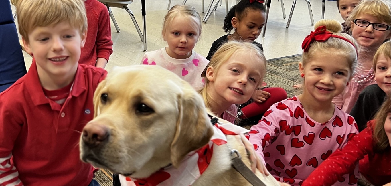 kindergarteners posing with facility dog